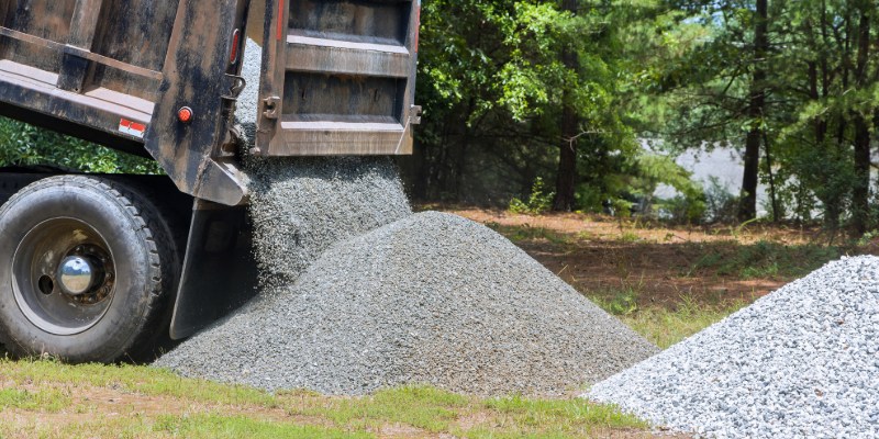 Raw gravel aggregate dumped by truck on construction site